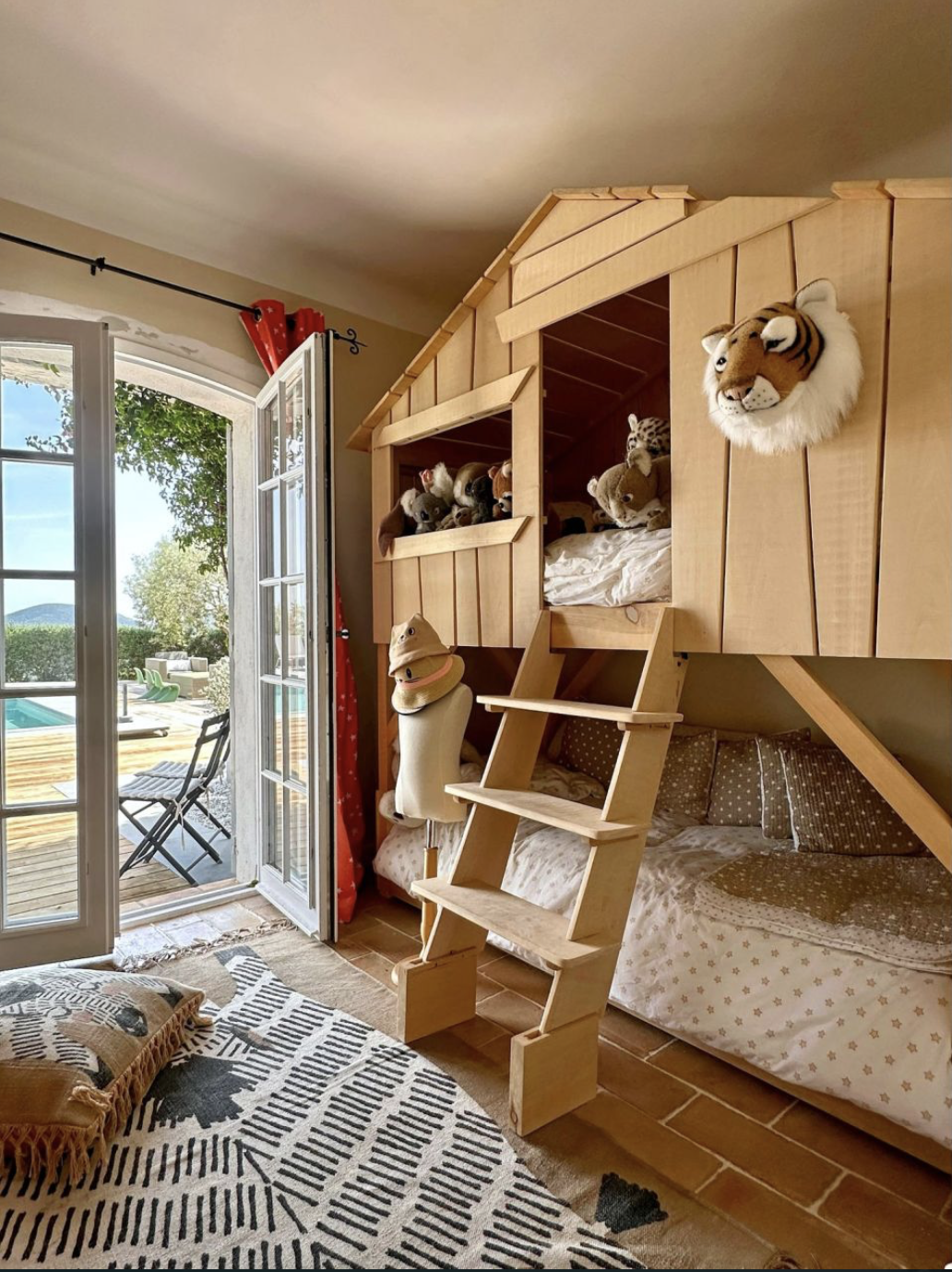 Lits superposés en bois façon maisonnette, accès terrasse piscine