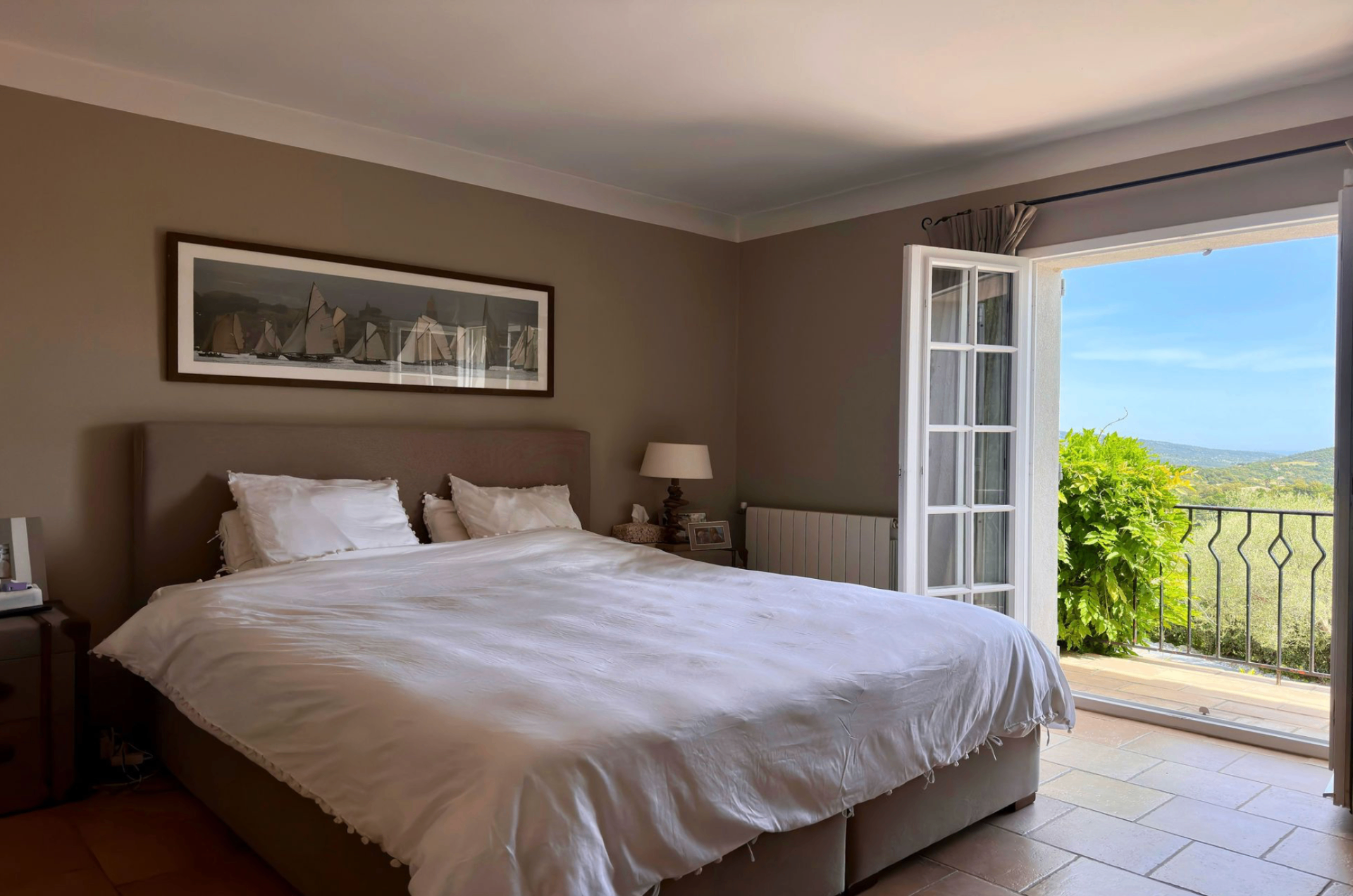 Chambre avec lit king size, porte-fenêtre et balcon vue collines